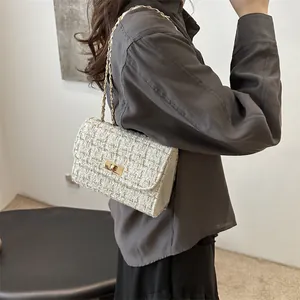 Sac bandoulière chic en tweed crème avec chaîne dorée et fermoir en métal sur l'épaule