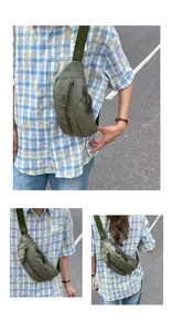 Close-up of olive green nylon sling bag featuring embossed text and woven zipper pulls
