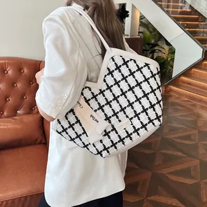 Minimalist black and white plaid tote bag with spacious interior and crossbody strap