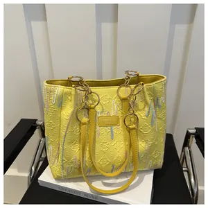 Détail du cabas jaune avec texture matelassée et broderie de lignes ondulées