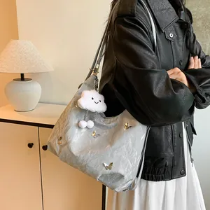 Minimalist silver hobo bag with butterfly charms and cute cloud plush keychain accessory