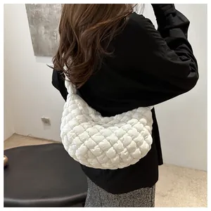 Detalle de la textura acolchada blanca y la forma de medialuna del bolso bandolera