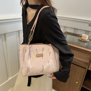 Sac cabas rose avec broderie arc-en-ciel et bandoulière chaîne sur un mannequin