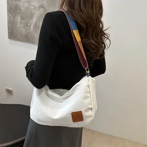 Sac bandoulière minimaliste en toile blanche avec large sangle colorée et cuir