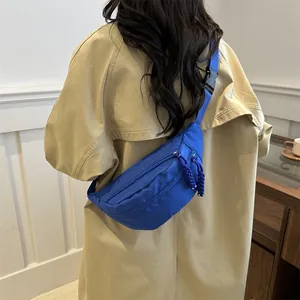 Minimalist Klein blue nylon cross-body chest bag with adjustable black strap on model