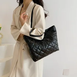 Sac fourre-tout matelassé noir avec lanières en cuir porté comme sac à bandoulière chic