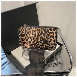 Detail of leopard print handbag with silver bead trim and metallic chain strap