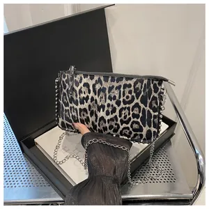 Detail shot of the animal print shoulder bag with silver studs and chain in a gift box