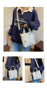 Detail of white leather handbag with rainbow ink splatter and adjustable shoulder strap