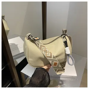 Détail du sac cylindrique kaki avec bandoulière tissée aux motifs ethniques géométriques