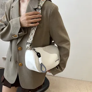 Sac bandoulière cylindrique blanc en nylon avec sangle à motifs porté par mannequin