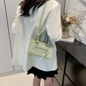 Minimalist mint green square handbag with decorative metal zipper and fringe tassels