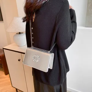 Sac bandoulière argenté chic avec boucle en strass et finition en similicuir métallisé