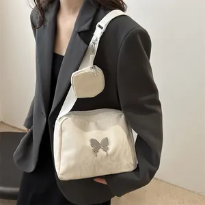 White pleated crossbody bag with silver butterfly buckle and small pouch accessory