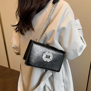 Sac bandoulière élégant en cuir noir avec boucle en strass brillante et bandoulière chaîne