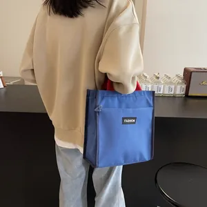 Stylish blue contrast tote bag with red handles and fashion logo for office or school