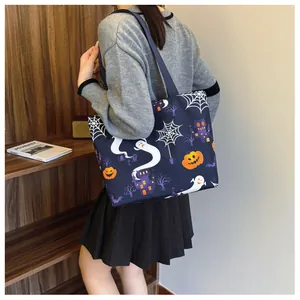 Lifestyle shot of Halloween tote bag featuring ghosts and pumpkins on a shoulder strap