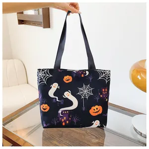 Detail of Halloween tote bag showing vibrant pumpkin, ghost, and castle prints on black canvas