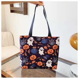 Detail of Halloween tote bag featuring festive pumpkin and ghost prints with black handles