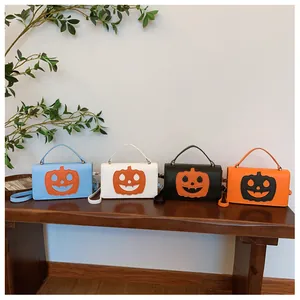 Detail view of four pumpkin-themed small square bags in blue, white, black, and orange colors