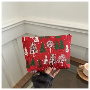 Handheld red Christmas tree clutch bag with festive pattern and metal zipper closure