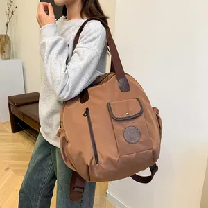 Brown lightweight nylon backpack for travel and commuting with multiple pockets and wide strap