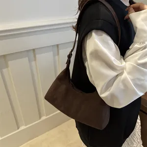 Sac hobo marron en simili daim avec bandoulière réglable porté par un mannequin