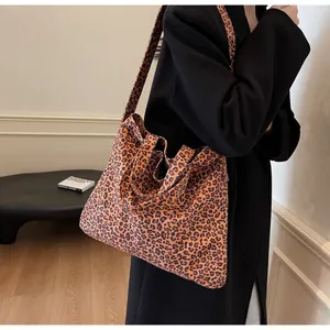 Fashionable leopard print tote bag styled with a black coat for an elegant street look