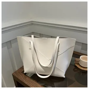Dettaglio delle cuciture geometriche sulla borsa tote in pelle PU beige per interni