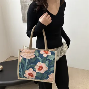 Floral oil painting tote bag in navy blue with pink flowers and woven handles