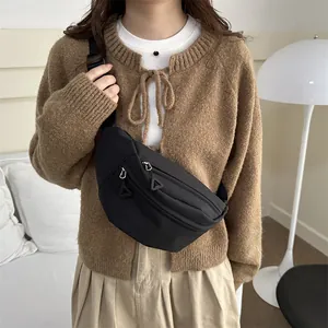 Minimalist black nylon crossbody chest bag with adjustable strap shown on model
