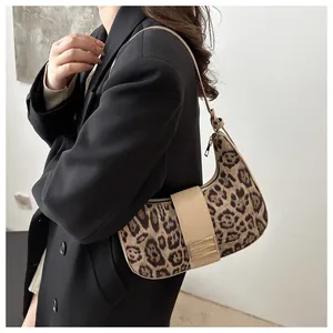 Détail d'un sac hobo à imprimé léopard avec bandoulière en cuir beige sur mannequin