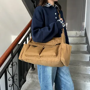 Borsa tote in tela kaki con grandi tasche anteriori indossata da una modella