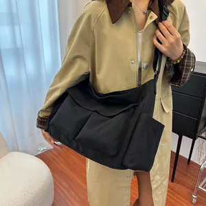 Minimalist black canvas tote bag for women in a casual winter style messenger design
