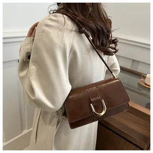 Deep brown retro faux leather shoulder bag with a gold U-shaped lock shown on a model