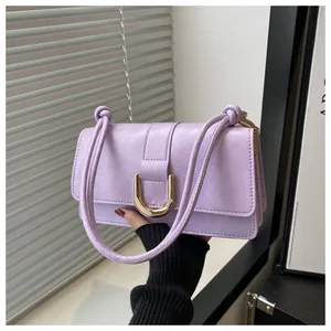 Close-up of lavender shoulder bag featuring a golden U-shaped buckle and textured leather