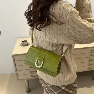 Grass green retro underarm bag with gold U-buckle shown on a model's shoulder