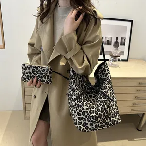 Chic leopard print tote bag with matching pouch shown on a beige trench coat