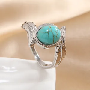 Detail of vintage silver ring with turquoise stone and intricate feather engravings
