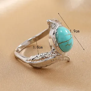 Detail of vintage boho wide band ring with turquoise stone and feather engraving