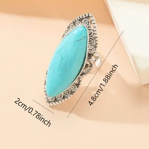 Detailed close-up of ethnic turquoise stone ring with vintage silver hollow patterns
