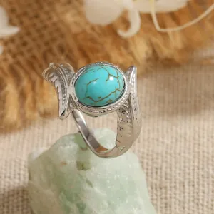 Vintage silver-tone wide ring with oval turquoise stone and intricate feather carvings