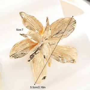 Close-up of golden petal ring showing 5.5cm diameter size and brushed metal texture