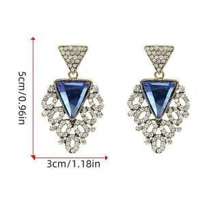 Macro detail of Bohemian fan-shaped earrings with blue rhinestones and gold alloy frame