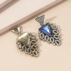 Macro detail of bohemian fan earrings with blue gemstone and gold vintage engraving