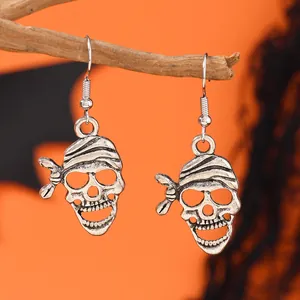 Vue détaillée des boucles d'oreilles crâne de pirate vintage sur branche décorative