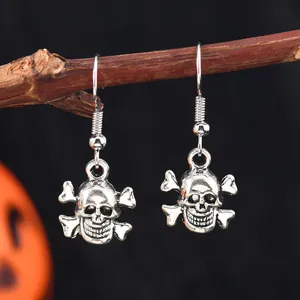 Vue détaillée de boucles d'oreilles tête de mort en argent vieilli sur une branche