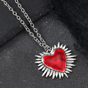 Macro shot of a Gothic heart pendant with red enamel and silver radial texture on stone