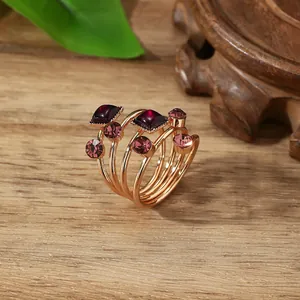 Detailweergave van de meerlaagse roségouden ring met facetgeslepen paarse edelstenen