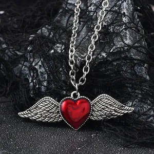 Macro view of gothic red heart pendant with silver wings on a chunky O-chain
